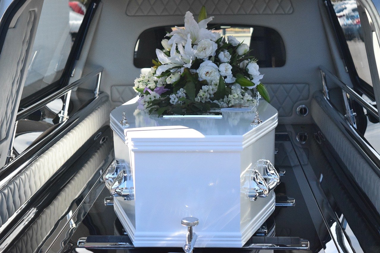 image of a white coffin inside a funeral vehicle