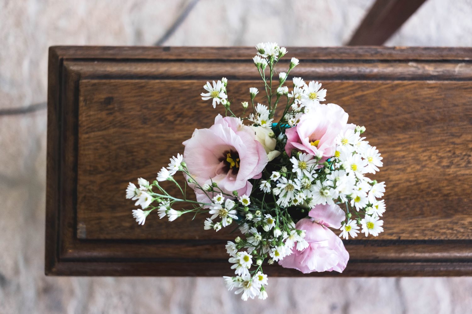 image of a casket with pink flowers on top